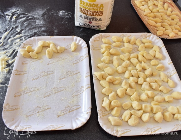 Обваляйте ньокки в муке и разложите на листе.
