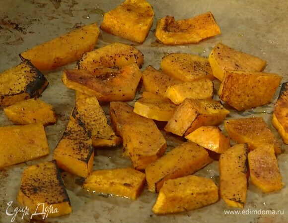 Тыкву почистить, нарезать тонкими ломтиками и выложить на застеленный пищевой бумагой противень, слегка посолить, поперчить, посыпать половиной кориандра и корицы, затем полить 2 ст. ложками оливкового масла Extra Virgin и запекать в разогретой духовке 20 минут.