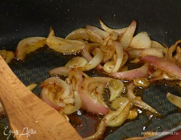 Чеснок почистить, нарезать тонкими пластинками и добавить к луку, посыпать оставшимся кориандром и корицей, сладкой паприкой, перцем чили и все обжарить.
