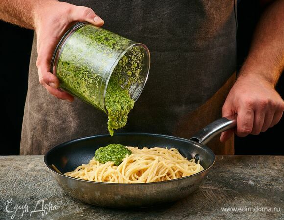 Перемешайте приготовленные спагетти и песто, добавляя воду с пасты по мере необходимости, чтобы получить кремообразную консистенцию.