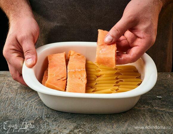 В форму для запекания выложите пасту пенне на дно. Сверху — рыбу. Повторите слой.