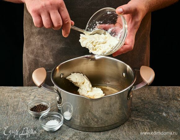 Добавьте сливочный сыр, соль и перец. Доведите до полного растворения.