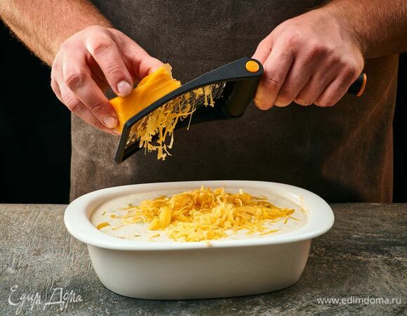 Сверху посыпьте тертым полутвердым сыром. Запекайте в духовке при 180°C около 20 минут до золотистой сырной корочки.