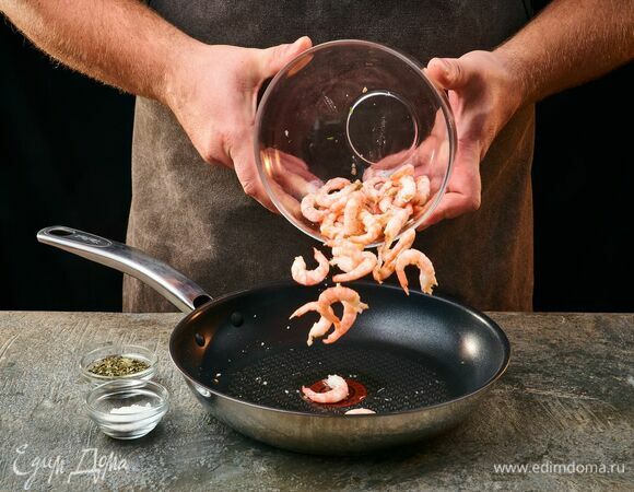 В разогретую сковороду влейте оливковое масло, обжарьте креветки с двух сторон, приправьте солью и прованскими травами. Обжаривайте креветки около 1 минуты.