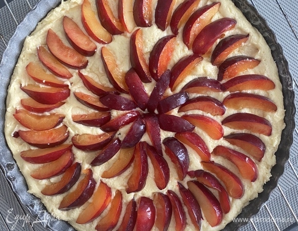 Рецепт рассчитан на форму диаметром 24 см. Все ингредиенты комнатной температуры. Сливочное масло взбить с сахаром до получения светлой пышной массы. Ввести по одному яйца, взбить до однородности. В 3 этапа добавить муку, затем — молоко комнатной температуры. Вымешиваем миксером на минимальной скорости или лопаткой вручную. Духовку разогреть до 180°C, режим «верх/низ». Форму для выпечки смазать сливочным маслом, посыпать мукой, стряхнуть излишки. Форму лучше выбрать разъемную (у меня съемное дно). Тесто выложить в форму, сверху разложить веером тонко нарезанные сливы. Посыпать сахаром, смешанным с корицей.