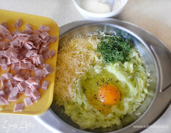 В миске смешайте кабачок, сыр (часть оставьте для посыпки), ветчину, укроп, яйцо. Приправьте перцем, добавьте муку и перемешайте. Муки может потребоваться чуть больше или меньше.
