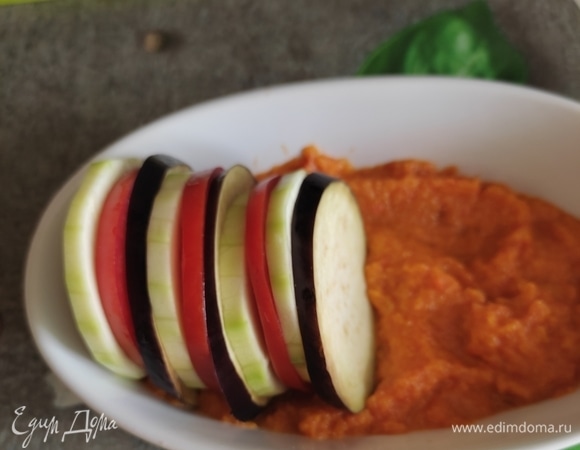 Далее выкладываем колечки овощей, чередуя кабачок, помидор, баклажан. Овощи как бы притапливаем в соус. Оливковое масло смешиваем с измельченным чесноком и прованскими травами, добавляем соль по вкусу и щедро поливаем наш рататуй. Формочки накрыть фольгой и отправить в духовку при 180°C на 30 минут. Затем снять фольгу и готовить овощи еще минут 20. Смотрите по своей духовке, они у всех разные! Рататуй готов, подаем, украсив зеленью.