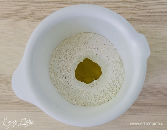 В муке сделать углубление и добавить соль, оливковое масло.