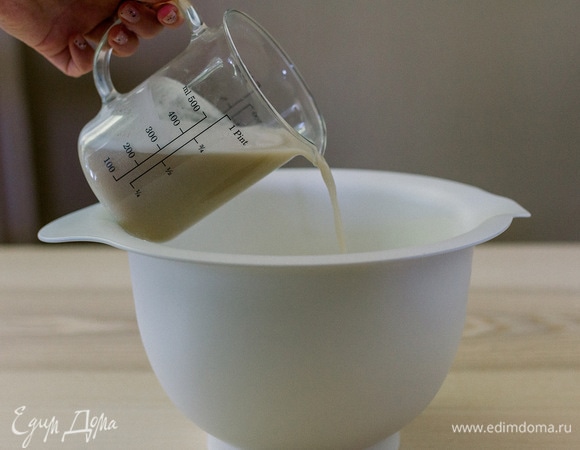 Постепенно вливать воду с дрожжами в муку, перемешивая.