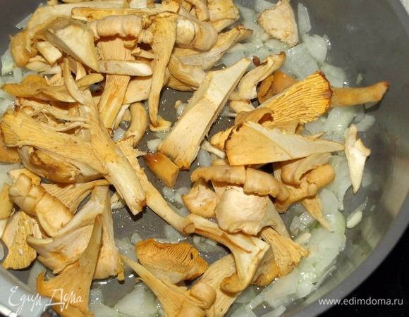 В глубокой сковороде на смеси растительного и сливочного масла обжарить лук и чеснок до мягкости лука. Добавить лисички и готовить 10 минут, изредка помешивая.