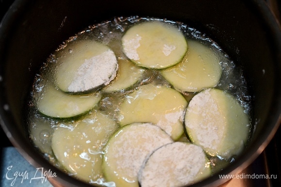 В сотейнике с толстым дном разогрейте растительное масло. Порциями (по 20–25 кружков) выкладывайте овощи.