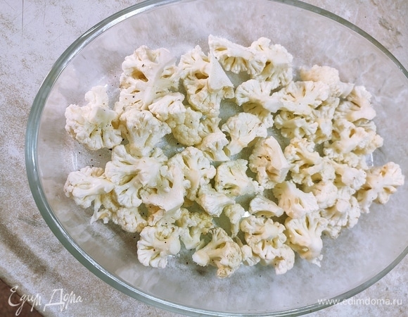 Цветную капусту разобрать на соцветия помельче, положить в форму для запекания. Посолить и поперчить по вкусу. Запекать в духовке 20 минут при температуре 200°C.