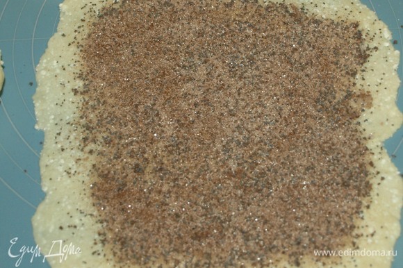 Раскатанное тесто посыпаем подготовленной смесью из сахара, мака и корицы. Равномерно распределяем.
