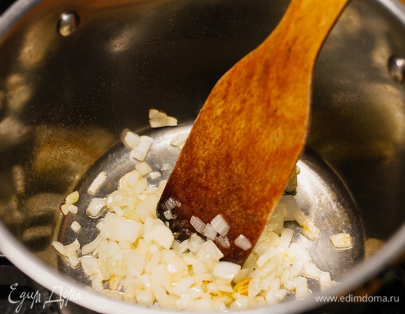 В кастрюлю налить немного оливкового масла и обжарить лук с чесноком.