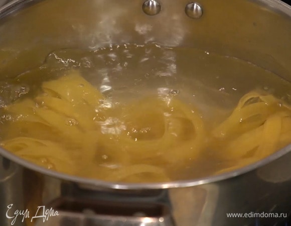 Феттучине отваривать в подсоленной воде на 1 минуту меньше, чем указано на упаковке, затем воду слить и сохранить, а макароны вернуть в кастрюлю.