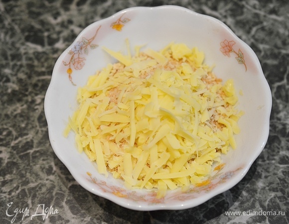 Панировочные сухари соедините с тертым сыром.