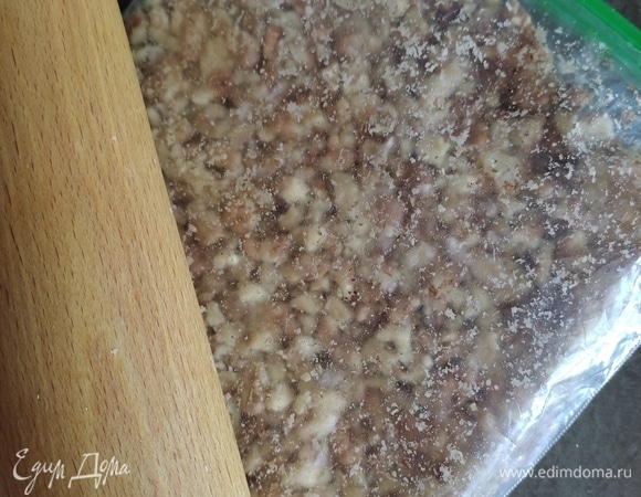 Орехи измельчить до крупной крошки. Я это делаю с помощью пакета и скалки.