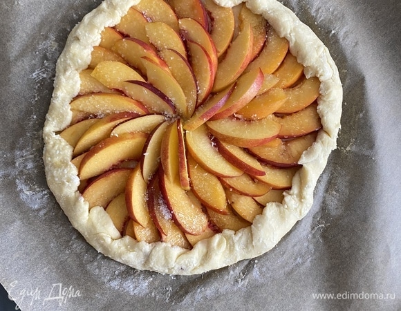 Все ингредиенты холодные! Соединить сливочное масло, творог, просеянную муку, соль и сахар, перемешать все до состояния крошки. Добавить 1 яйцо и быстро замесить тесто. Готовое тесто завернуть в пакет, убрать на 1 час в холодильник или на 25 минут в морозилку. Нектарины нарезать тонкими дольками. Спустя время раскатать тесто между двумя слоями пергамента в круг диаметром 24 см. Выложить веером нарезанные нектарины, не доходя до края 2 см, посыпать сахаром. Загнуть края по всему периметру и прижать, формируя пирог. Края слегка смазать водой и посыпать сахаром.
