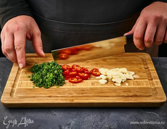 Для маринада перец чили нарежьте кружочками, кинзу и чеснок порубите. Все выложите в чашку.