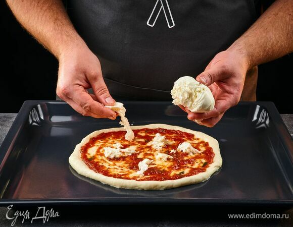 Моцареллу порвите на кусочки и выложите на тесто.