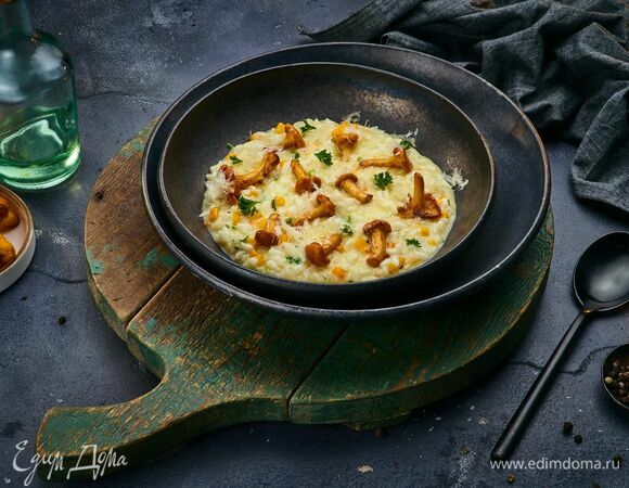 По приготовлению ризотто добавьте обжаренные лисички и овощи, перемешайте. Разложите блюдо по тарелкам, посыпьте рубленой петрушкой, тертым сыром и подавайте!