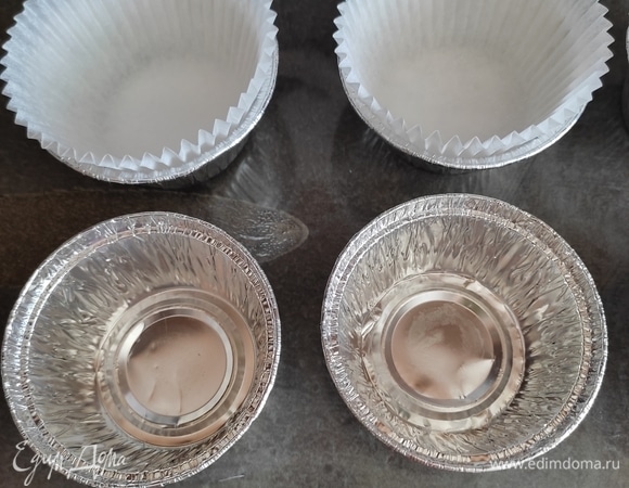 Подготовить формочки. Я выпекаю в алюминиевых формах, предварительно вкладываю туда бумажные капсулы, что позволяет несколько раз использовать емкость для выпечки. Обязательно смазать бумажные капсулы растительным маслом, иначе кексы прилипнут.