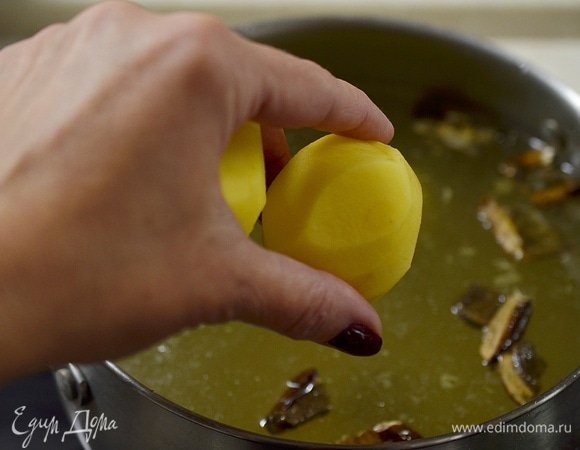 Картофель почистите и целиком добавьте в бульон.