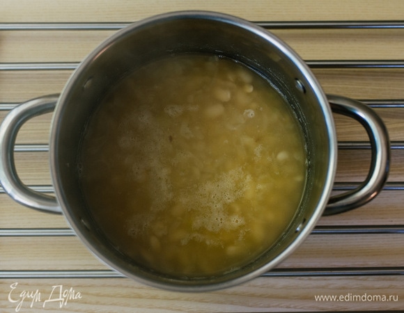 Добавить лук с чесноком к фасоли, посолить, поперчить по вкусу и варить еще 10 минут.