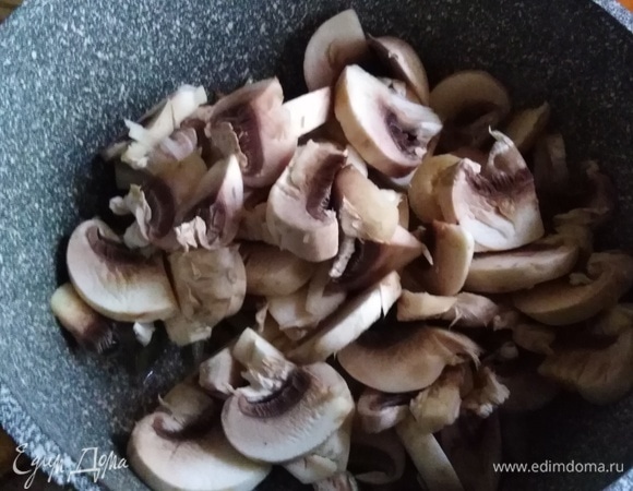 Добавить нарезанные шампиньоны. Жарить в течение 7–10 минут.