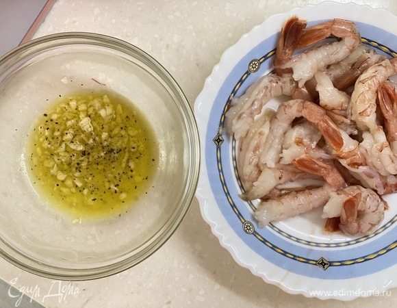 В миске смешать вино, оливковое масло и чеснок. Добавить соль и перец по вкусу. Смешать маринад с очищенными креветками.