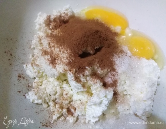 В творог вбить яйца. Добавить соль, сахар, сметану, ванилин и корицу.