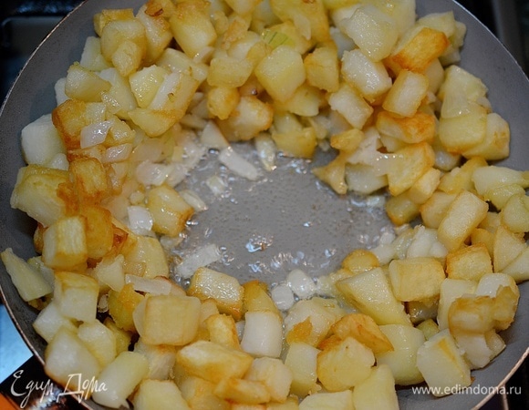 Перемешайте, отодвиньте к краям сковороды обжаренную картошку с луком.