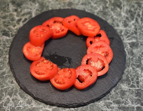 На тарелку для подачи выложите по кругу кружки помидоров.