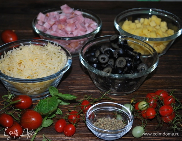 Подготовьте продукты для пасты. Ветчину нарежьте ровными кубиками, лучше взять постную, нежирную ветчину. Оливки нарежьте колечками, твердый сыр натрите на мелкой терке (отлично подойдет пармезан). Сыр, который помягче, нарежьте ровными кубиками, как и ветчину.