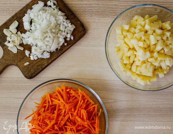 Морковь нарезать мелкой соломкой, картофель и лук — небольшими кубиками, а чеснок — пластинками.