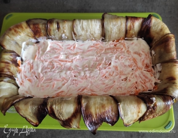 Далее выкладываем слой тертой моркови, также смазываем майонезом с чесноком.