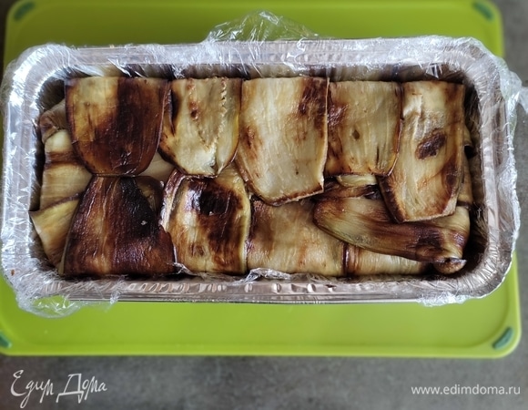 Закрываем дно слайсами баклажана и ставим форму в холодильник минимум на 3 часа, лучше — на ночь. После чего достаем и аккуратно переворачиваем на блюдо. Снимаем пищевую пленку, и можно подавать.