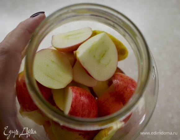 В стерилизованные банки уложите яблоки. Банки должны быть заполнены на 1/3.