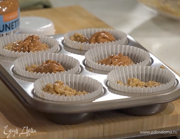 Формочки для маффинов наполовину наполнить тестом, в каждую добавить по одной чайной ложке ореховой пасты, затем разложить оставшееся тесто.