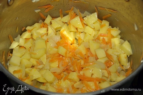 Картофель очистить, промыть и нарезать некрупными кубиками. Добавить к остальным овощам и томить, постоянно помешивая, 5 минут.