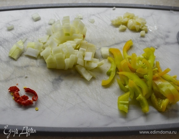 Лук и чеснок (1 зубчик) почистите, нарежьте кубиком. Сладкий перец — соломкой, острый — колечками.