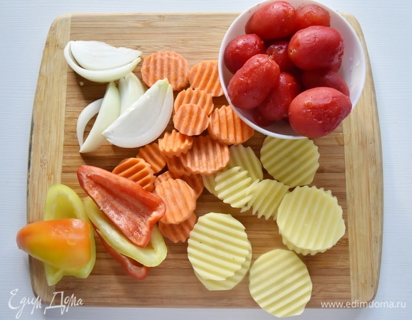 Готовлю овощи. Очищаю и нарезаю достаточно крупными кусочками. Для нарезки картофеля и моркови использую терку с гофрированным лезвием. Помидоры заливаю кипятком и оставляю на время, затем снимаю с них кожуру. Если помидоры некрупные, можно оставить их целыми.