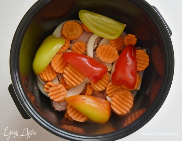 На дно чаши мультиварки кладу немного говяжьего жира, срезанного с ребер. Добавляю часть растертой зелени с чесноком и специями. Выкладываю лук, мясо, овощи, подсаливаю, пересыпаю специями и чередую слои друг за другом.