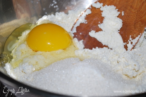 Выложите протертый творог в миску. Добавьте куриное яйцо, сахар, ванильный сахар по вкусу и соль, хорошо перемешайте.