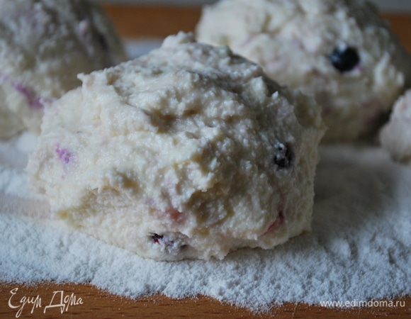 На большую деревянную доску насыпьте 2 ст. л. рисовой муки. Творожное тесто для сырников берите влажными руками небольшими порциями и обваливайте в муке. У вас получится 4 заготовки. Тесто для сырников можно предварительно убрать в холодильник на 30 минут — с холодным тестом вам будет легче работать.