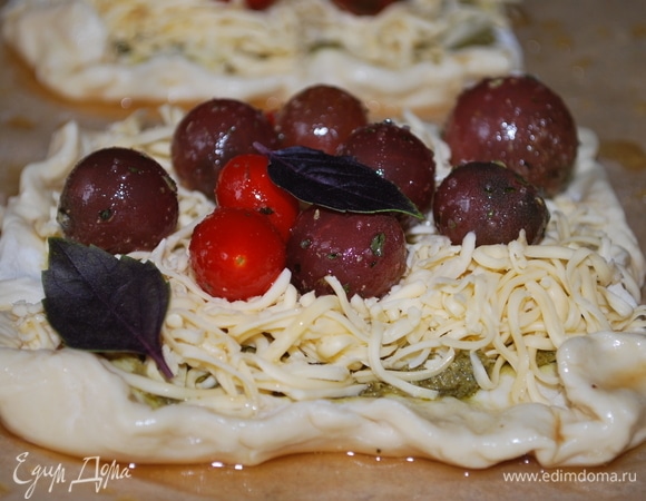 Выложите ароматные помидоры на сыр. Края теста смажьте яйцом или тем, чем вы привыкли смазывать тесто для придания ему красивой корочки. Посыпьте сверху кунжутом. Выпекайте в разогретой духовке при 180°C в течение 15–18 минут.