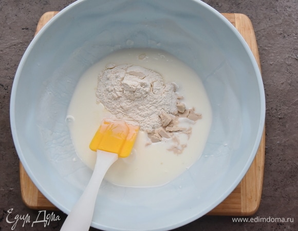 В миску вливаю кефир и подогреваю его в микроволновой печи 1,5 минуты. Добавляю соду, сахар, две столовые ложки муки из общего количества и свежие дрожжи.