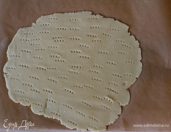 Тесто раскатать на пергаменте в пласт толщиной примерно 0,5 мм и наколоть вилкой. Выпекать при 180°C до золотистого цвета. Остудить.