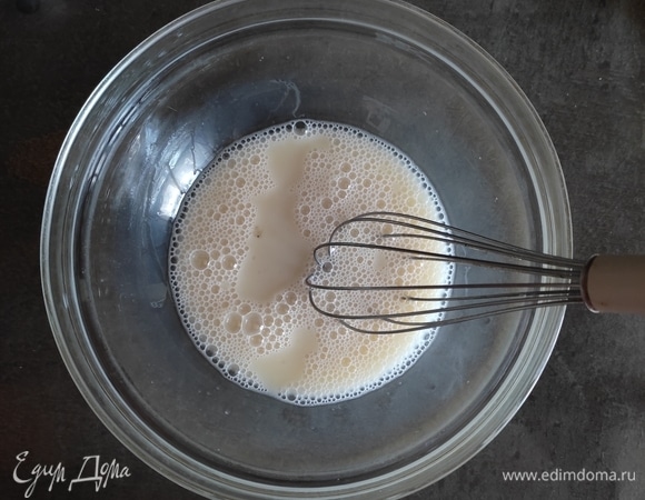 В чаше соединяем теплое молоко и воду, добавляем сухие дрожжи, перемешиваем венчиком и отставляем на 5 минут.