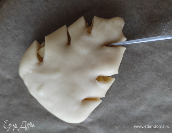 Далее с помощью ножниц делаем по бокам надрезы. Не делайте слишком глубокие, чтобы при выпекании не вытекла начинка.